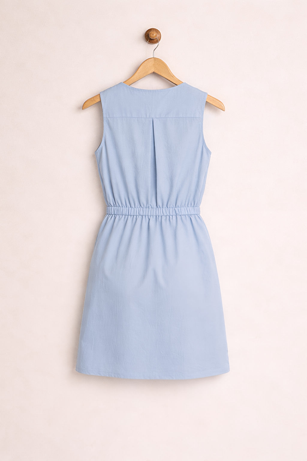 Light blue dress on a hanger against a plain background