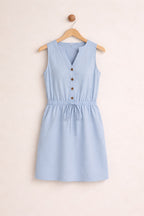 Light blue sleeveless dress with buttons on a beige background