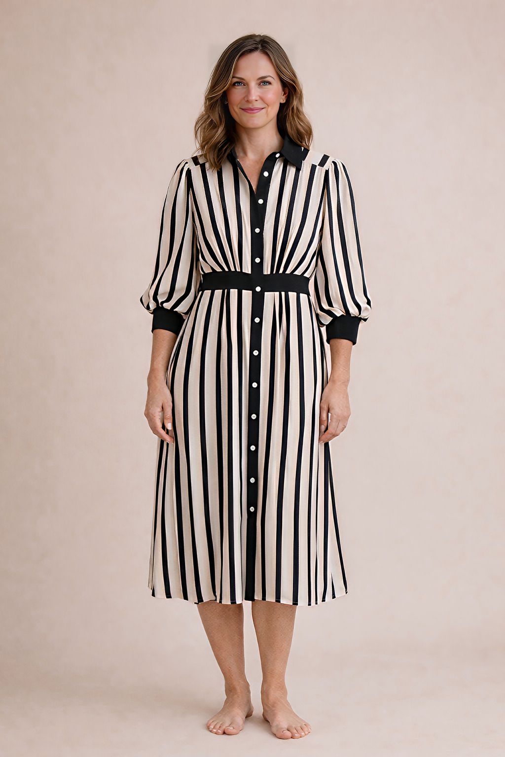 Woman wearing a black and white striped dress on a beige background