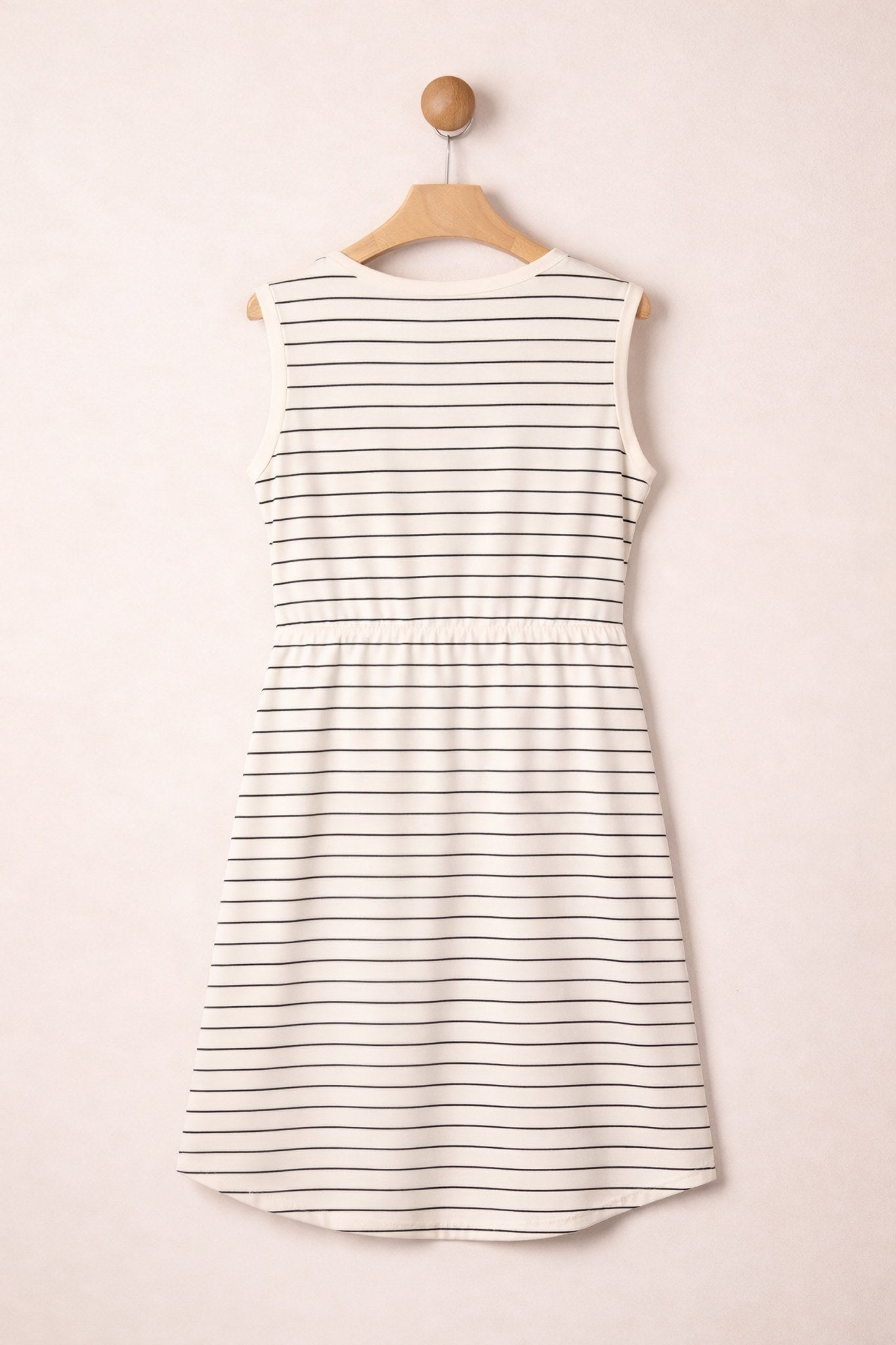 Striped dress on a hanger against a plain background