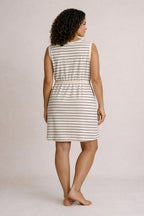 Woman wearing a striped dress against a plain background