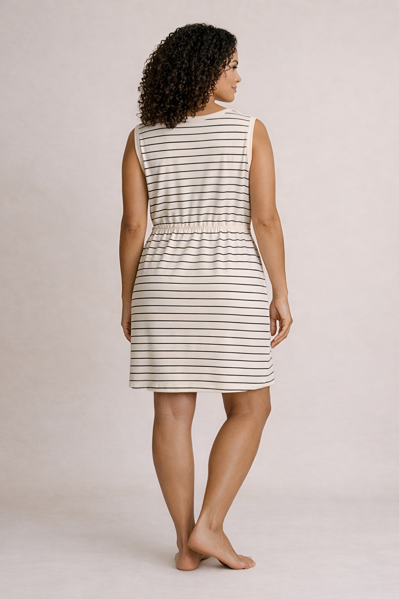 Woman wearing a striped dress against a plain background