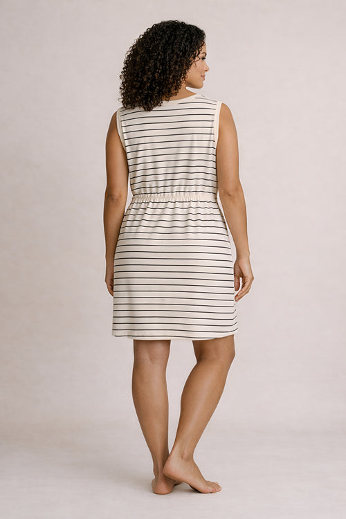 Woman wearing a striped dress against a plain background