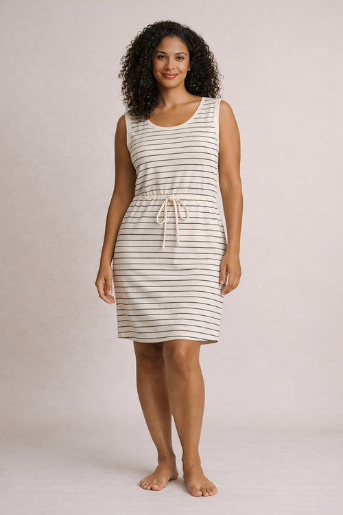 Woman wearing a striped dress against a plain background