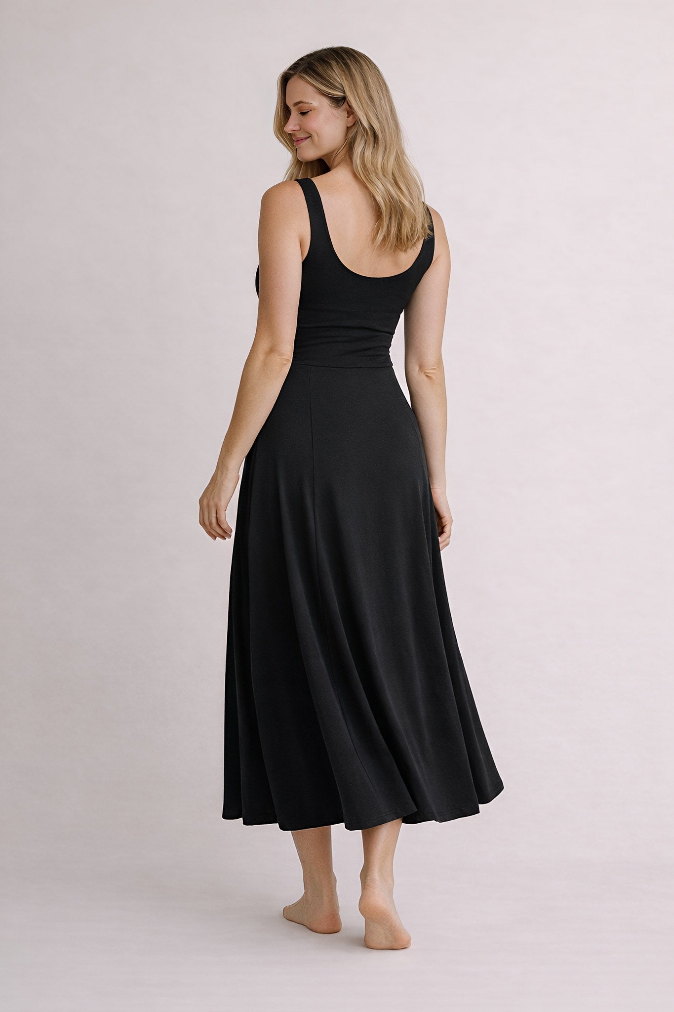 Woman wearing a black dress on a plain background