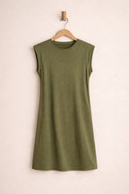 Green sleeveless dress on a wooden hanger against a beige background