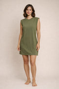 Woman wearing a green dress against a beige background