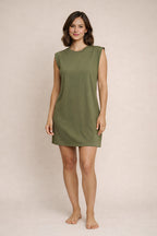 Woman wearing a green dress against a beige background