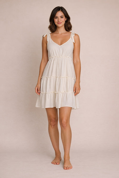 Woman wearing a white dress against a beige background