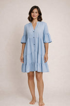 Woman wearing a light blue dress against a plain background